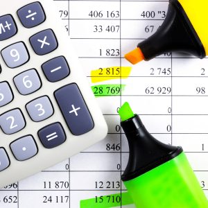 Calculator, highlighter and markers on financial statements.
